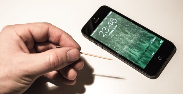 iPhone with hand holding toothpick